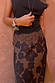 Maeva Skirt in Tan Jaden Floral Print with lace trim, styled with a black top and gold jewellery