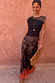 Maeva Skirt in Tan Jaden Floral Print with orange lace hem, styled with a black top and tan clutch bag.