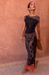 Maeva Skirt in Tan Jaden Floral Print with orange lace trim, worn by a model against a clay wall.