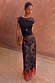 Model wearing the Maeva Skirt in Tan Jaden Floral Print with orange lace trim and a black top.