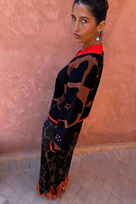 Modella con Gonna Maeva in stampa floreale Jaden marrone, orlo in pizzo arancione e maglia coordinata.