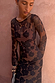 Model wearing Mesh Dress in Tan Jaden Floral Print with long sleeves against a textured wall