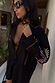 Camicia nera con ricami di palme sulle maniche, indossata con occhiali da sole per un look da vacanza.