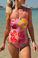 Costume intero rosa con vivace stampa a francobolli di frutta indossato in riva al mare.