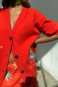 Cardigan Red Celestial rosso con ricami a stella e bottoni scuri, abbinato a un set coordinato.