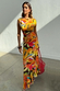 Rio A-Symmetric Skirt in a multi-coloured tropical fruit print worn by a model with a matching co-ord top.
