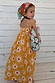Girl wearing a yellow cotton sun dress with white sun print and shirred top.