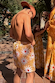 Boy wearing yellow sun swim shorts with a white and orange soleil print in a sunny outdoor setting.
