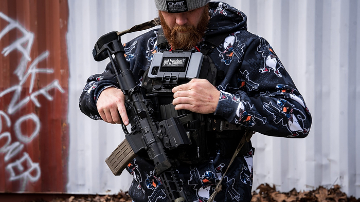 A man with outdoor gear in hoodie