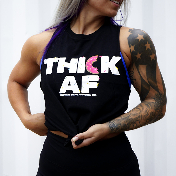 Tattooed lady wearing a black thick af donut edition Combat Iron Apparel Co. crop top, showing how perfect it fits.