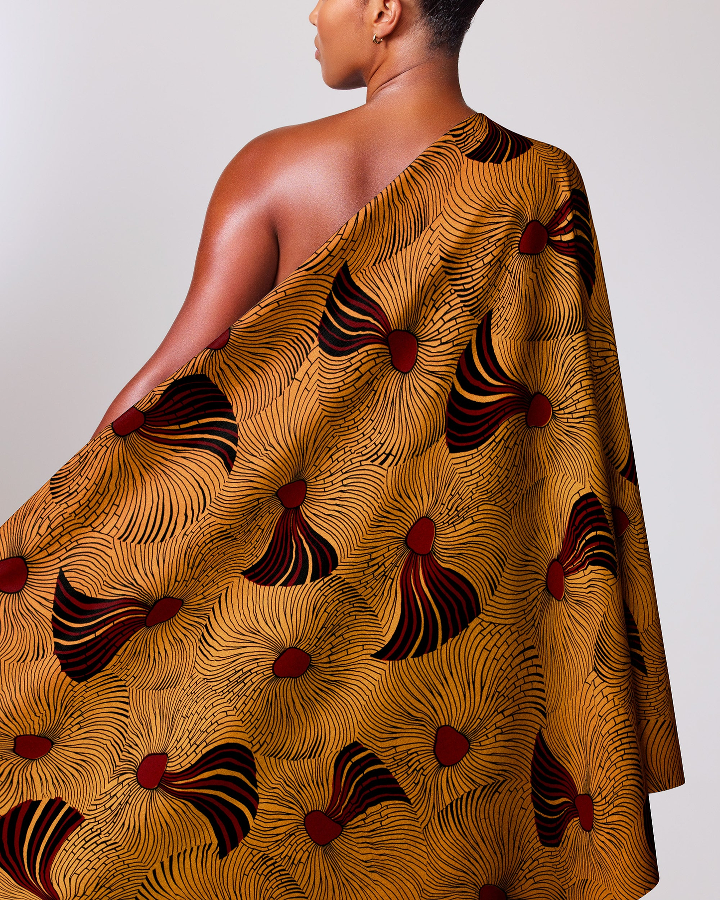 Woman wears one-shoulder dress made wax hollandais vl03586.098