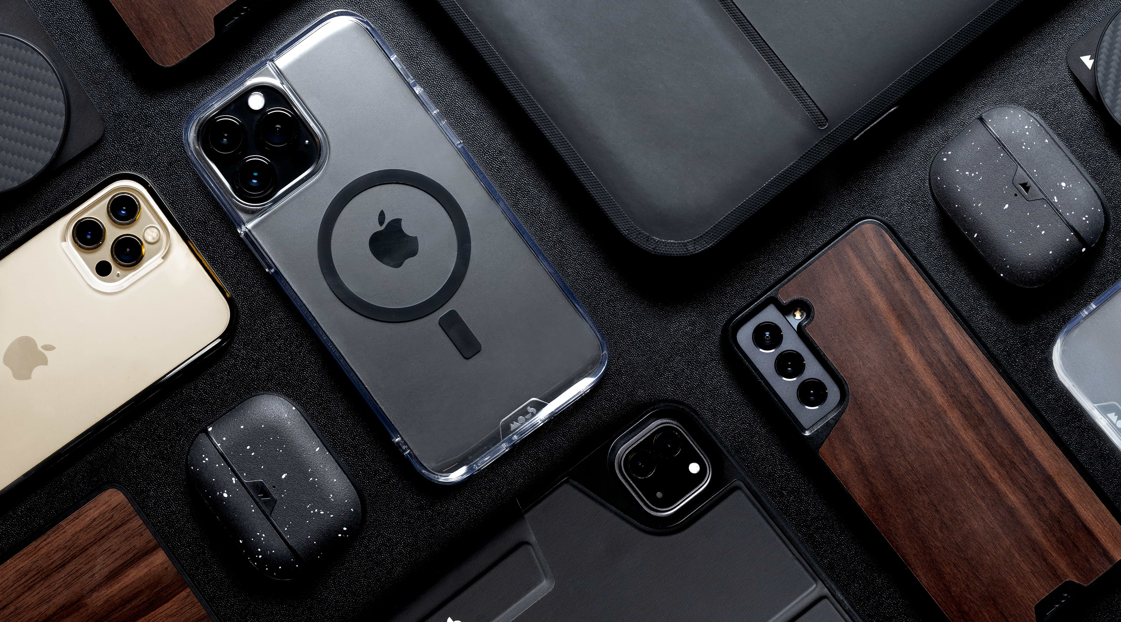 Flat lay of Mous tech accessories with MagSafe compatible cases, clear cases, a MacBook sleeve and AirPods cases