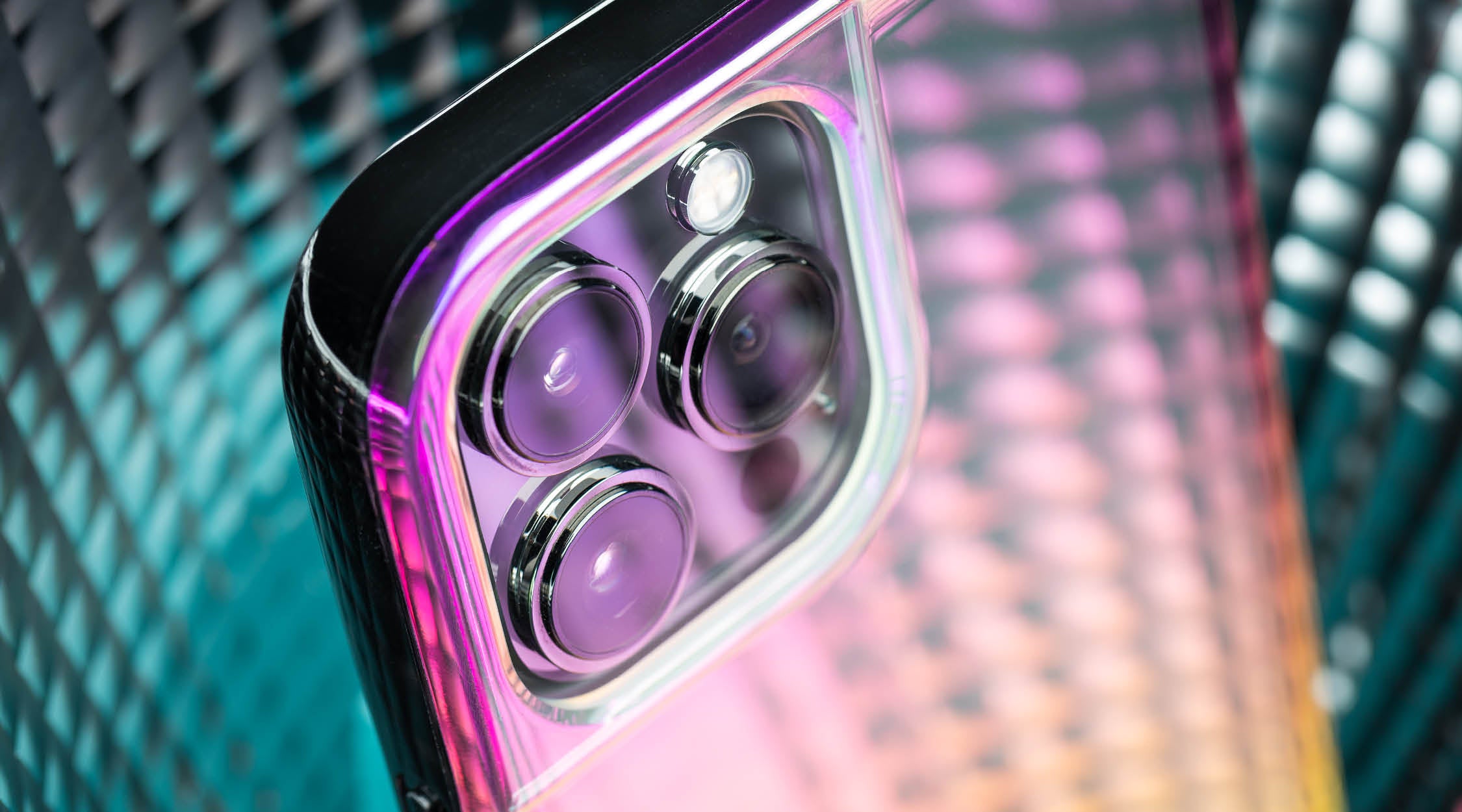 Pink and yellow iridescent phone case for iPhone 13 Pro Max on a blue background