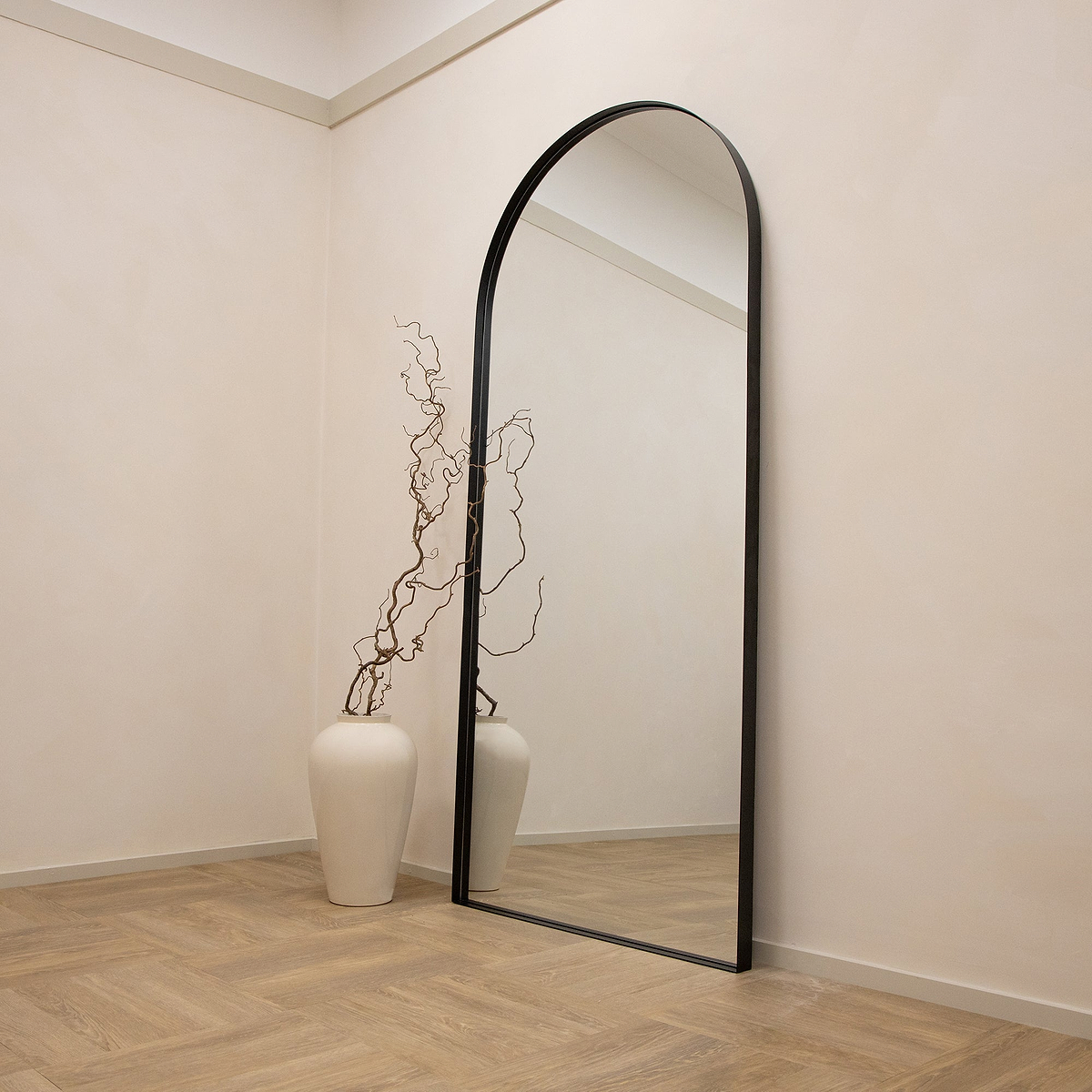 Full length arched black XXL metal mirror leaning against wall
