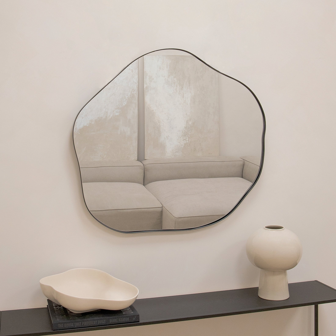 Irregular wall mirror above a console table