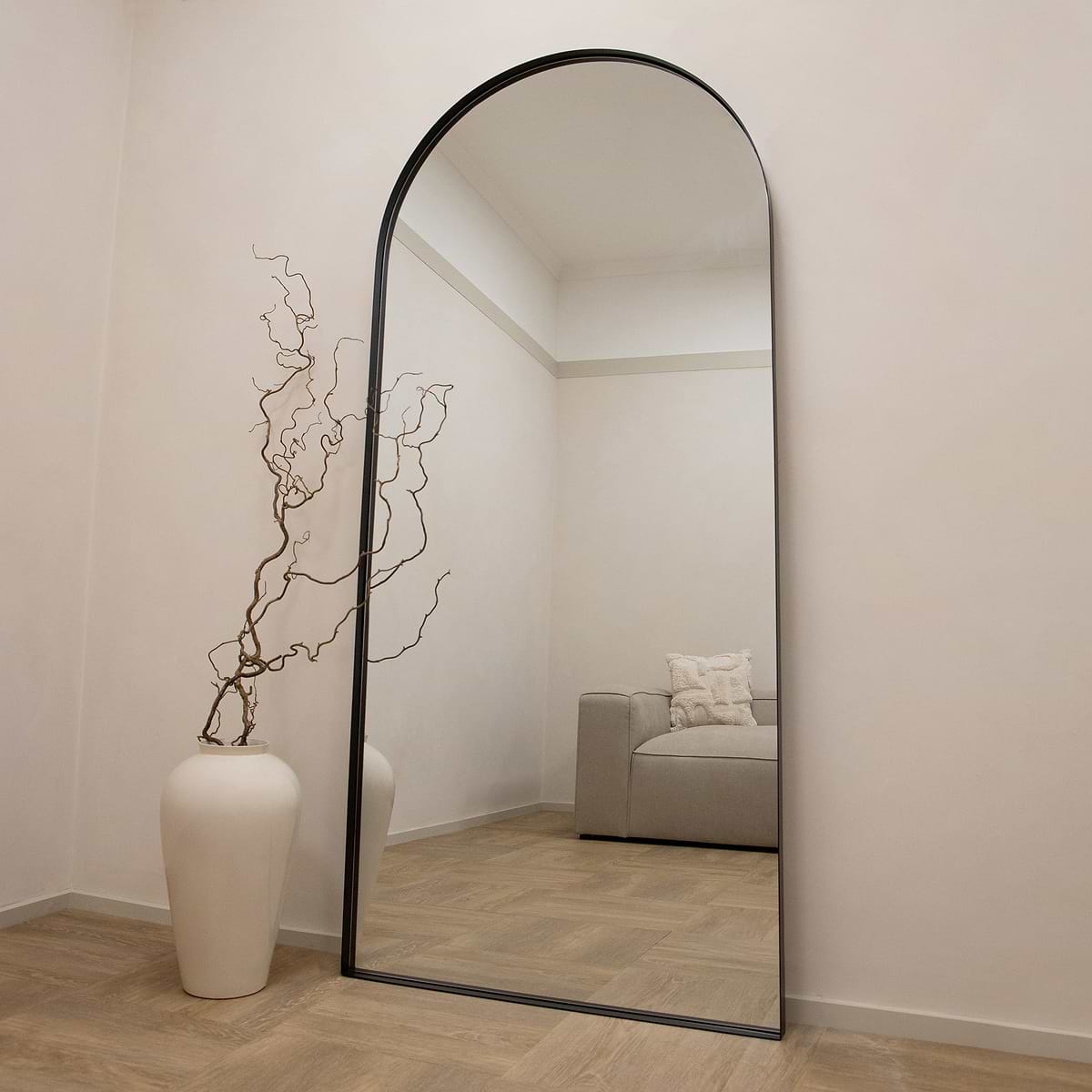 Full length arched black XXL metal mirror leaning against wall