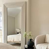 Full length ribbed concrete mirror leaning against wall