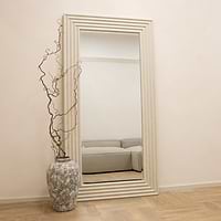 Full length ribbed concrete mirror leaning against wall