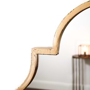 Closeup of gold industrial arched metal large mirror
