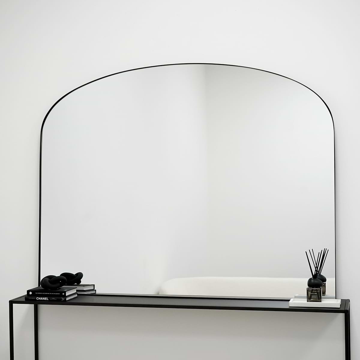 Black metal overmantle large wall mirror displayed on console table