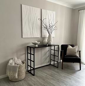 Black modern large rectangle tinted mirrored console table beside chair