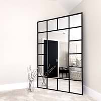 Black industrial full length metal window mirror in room corner