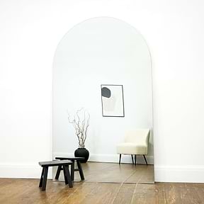 Extra large frameless arched full length mirror by stool