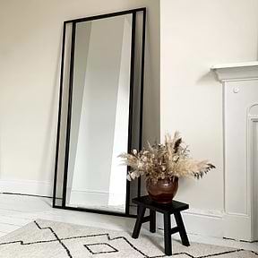 Full Length Black Metal Mirror beside fireplace