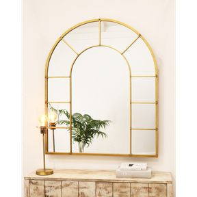 Gold industrial arched full length metal mirror on wall
