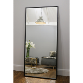 Full Length Black Industrial Metal Mirror reflecting light in living room