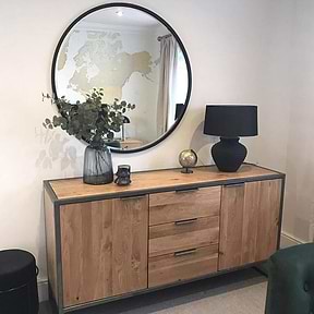 Black Metal Modern Round Wall Mirror on wall amonst vases