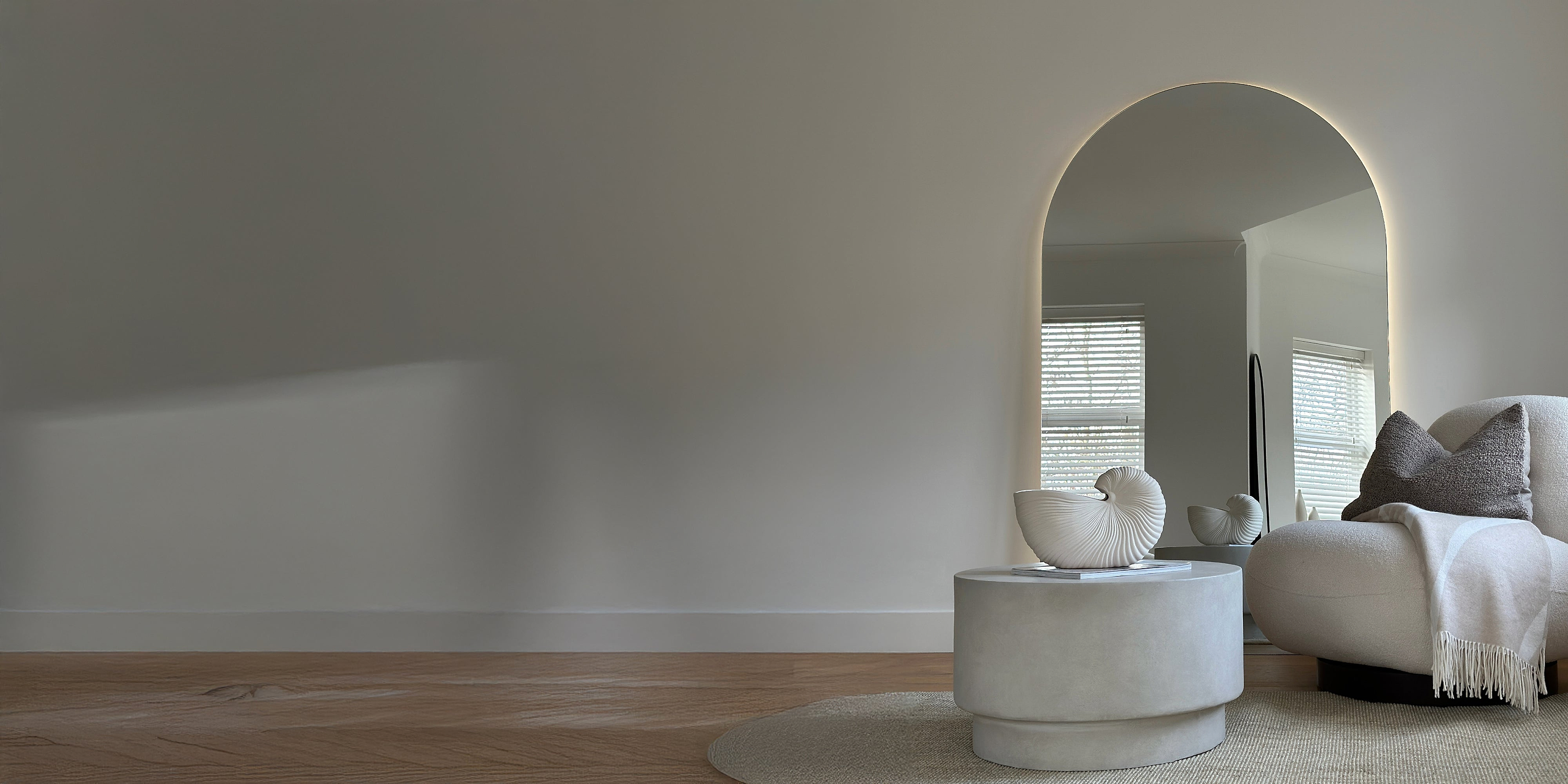 A backlit mirror and coffee table in a lounge setting