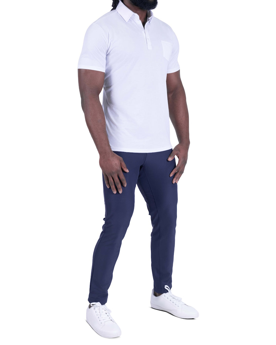 Person wearing a white polo shirt and navy pants on a white background