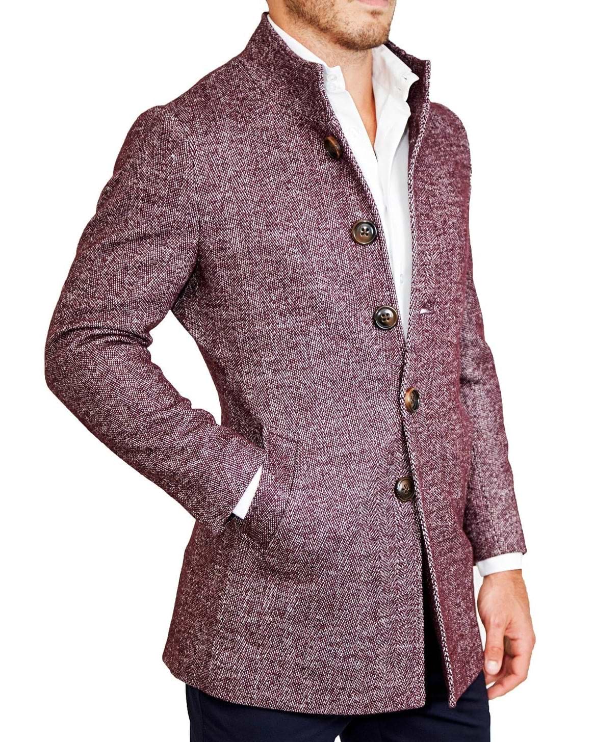 A man wearing a maroon herringbone open button overcoat with a white shirt and blue trousers.