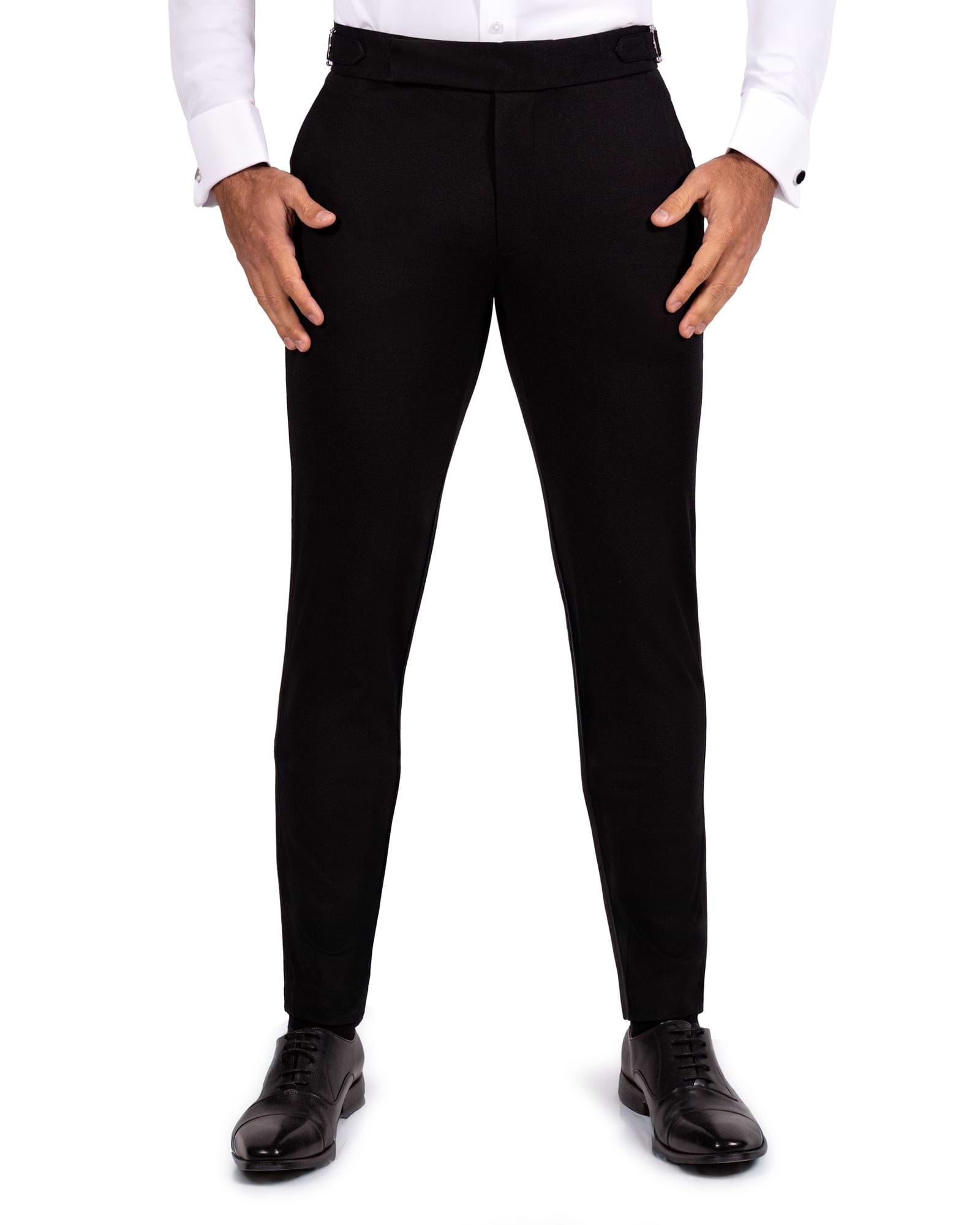 Black dress pants worn with a white shirt and black shoes on a white background