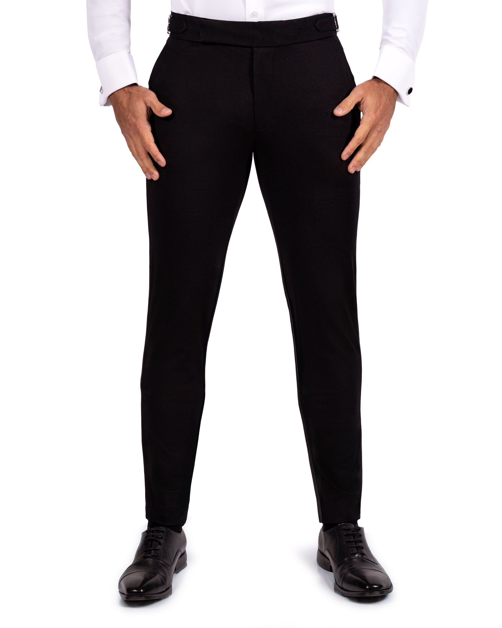 Black dress pants worn with a white shirt and black shoes on a white background