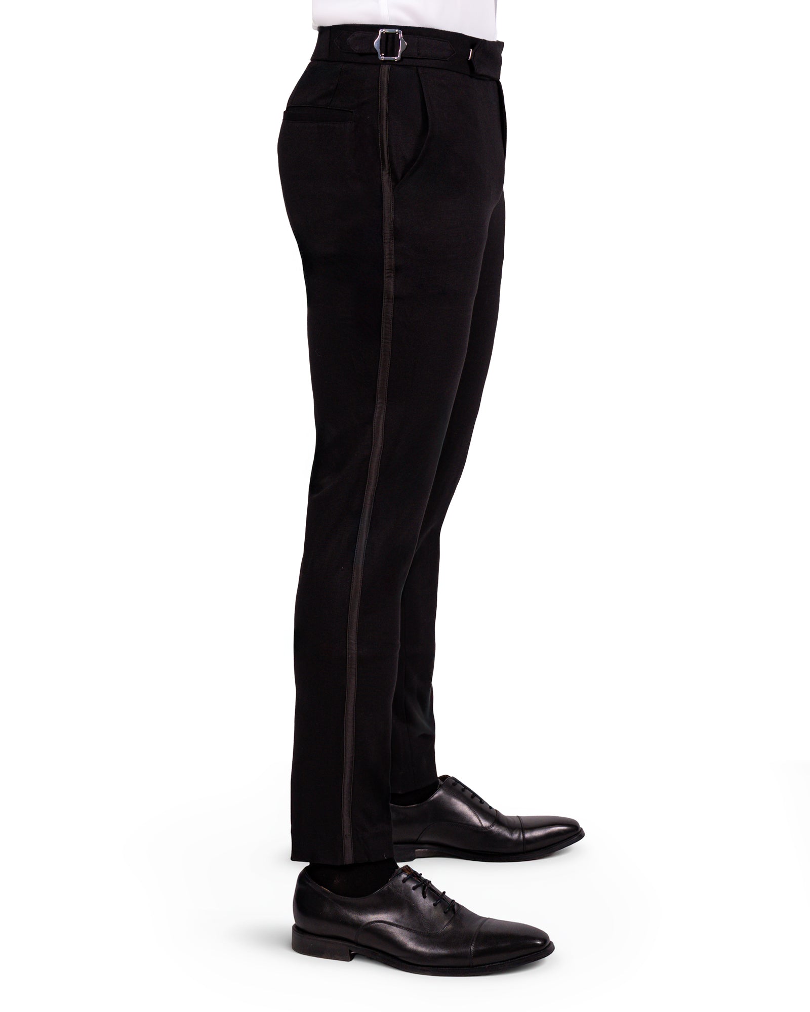 Black dress pants worn by a person on a white background