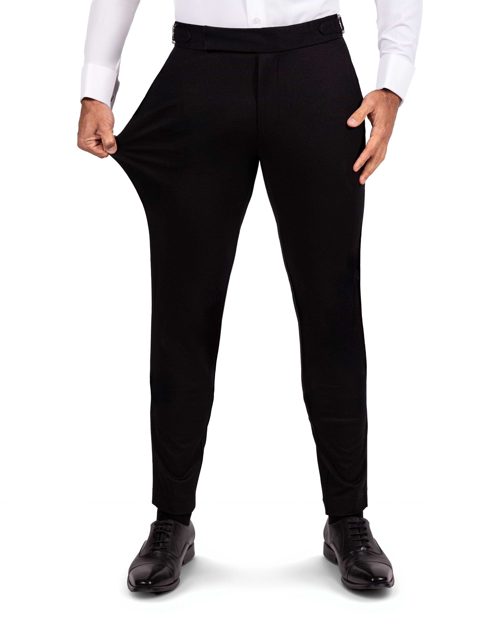 Black dress pants worn by a person on a white background