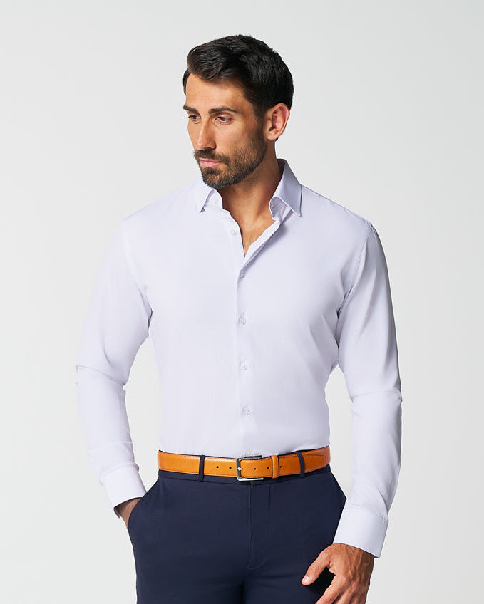 Man wearing a white dress shirt, navy pants, and brown shoes on a white background