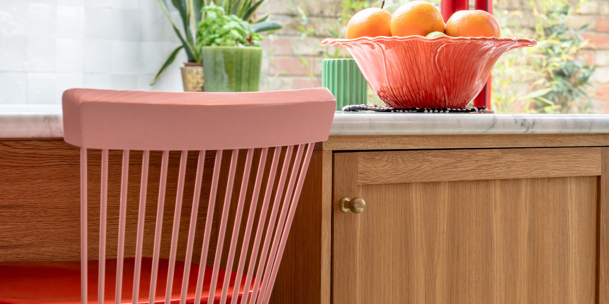 Contemporary kitchen filled with accent colours, with an antique brass 'Bayswater Furniture Knob' on a wooden cupboard.