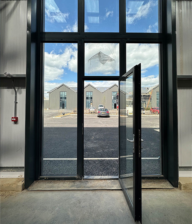 A spacious warehouse with tall shelves filled with cardboard boxes, organized and awaiting distribution.