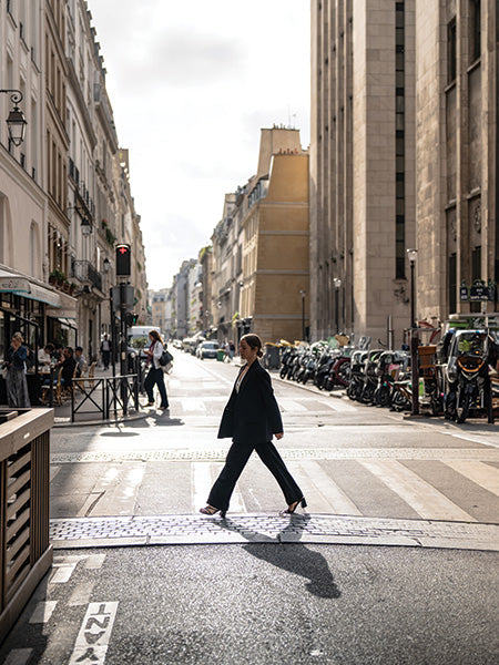 A person striding across a pedestrian crosswalk.