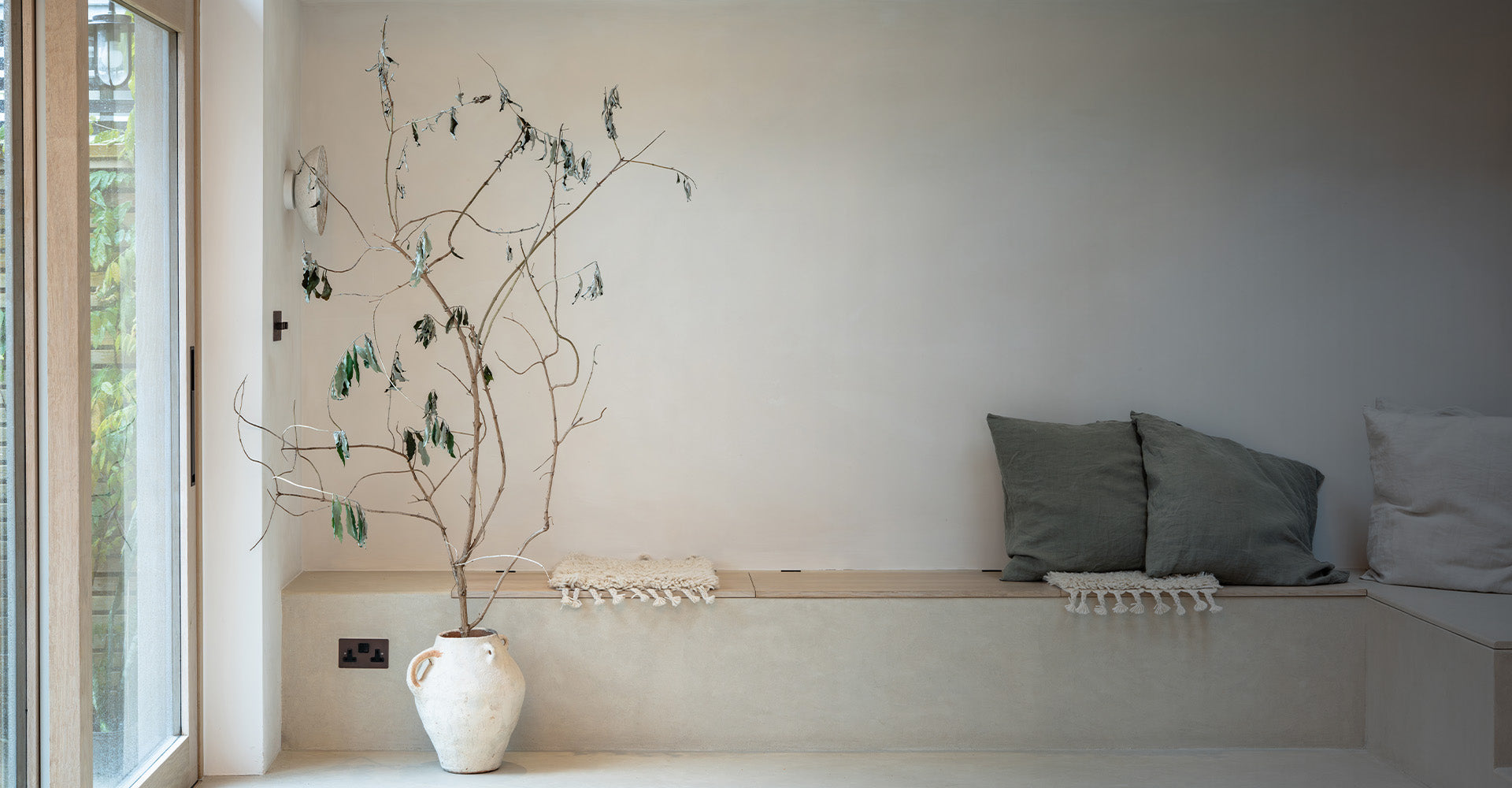 A dried plant, with a bronze outlet behind it