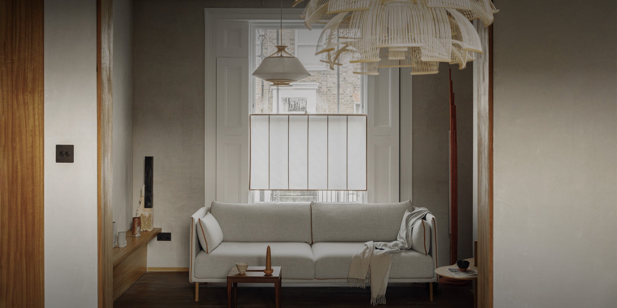 Stylish modern living room featuring a cozy sofa, wooden accents, and contemporary lighting, inviting relaxation and conversation.