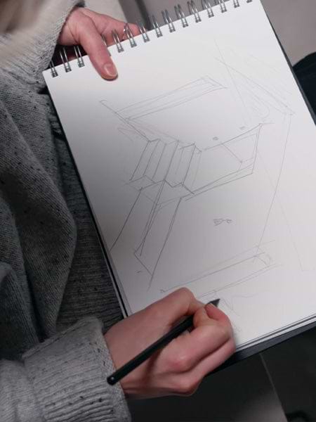 Person sketching an architectural structure.