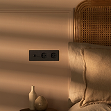 Bronze- und schwarzer Dreifachrahmen mit 2 Kipphebel- & SchuKo-Modulen, elegant eingefasst in einen runden Dreifachrahmen.