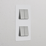 Dubbele Wissel-Wipschakelaar met verticale afdekplaat, in overschilderbaar gepolijst nikkelwit, voor op de muur.