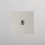 Lichte tuimelschakelaar op witte achtergrond: enkele tuimelschakelaar van Gepolijst Nikkel