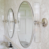 Claremont Medium Wandlamp met geribbeld glas en gepolijste nikkel afwerking, gemonteerd tegen bloemenbehang.