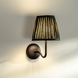 Malvern Medium Wandlamp in Diepgroen onder een hoek bevestigd aan een muur en aangezet